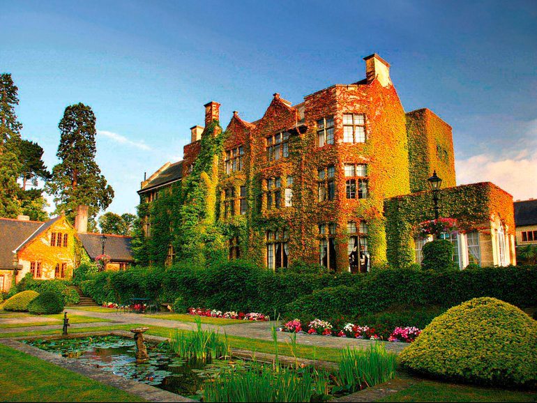 Sun shinning on the Pennyhill Park building covered in vines.
