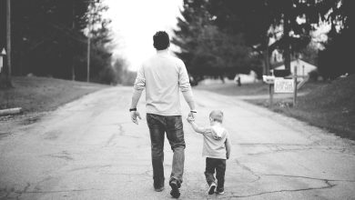 Father and kid walking together, black and white photo