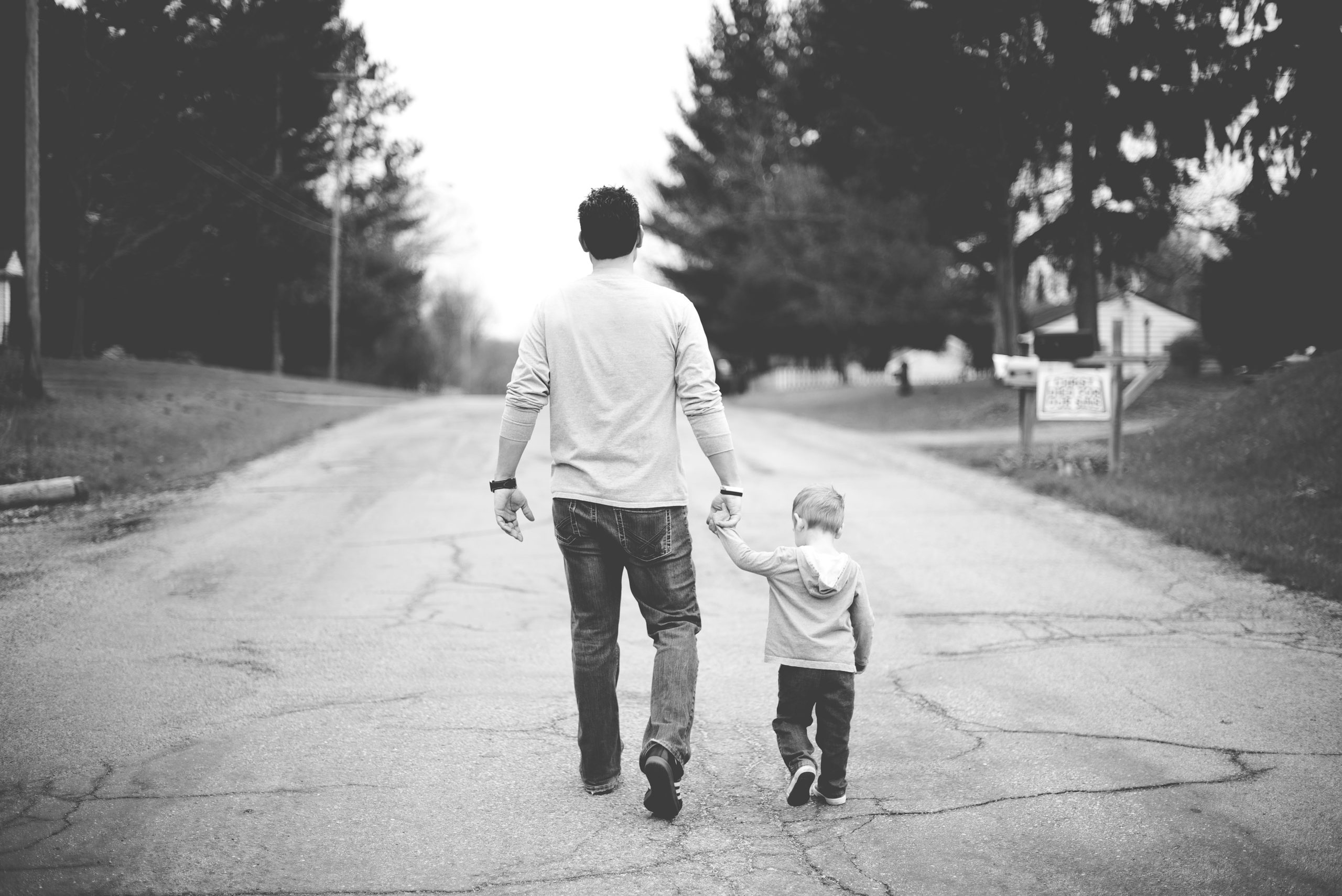 Father and kid walking together, black and white photo